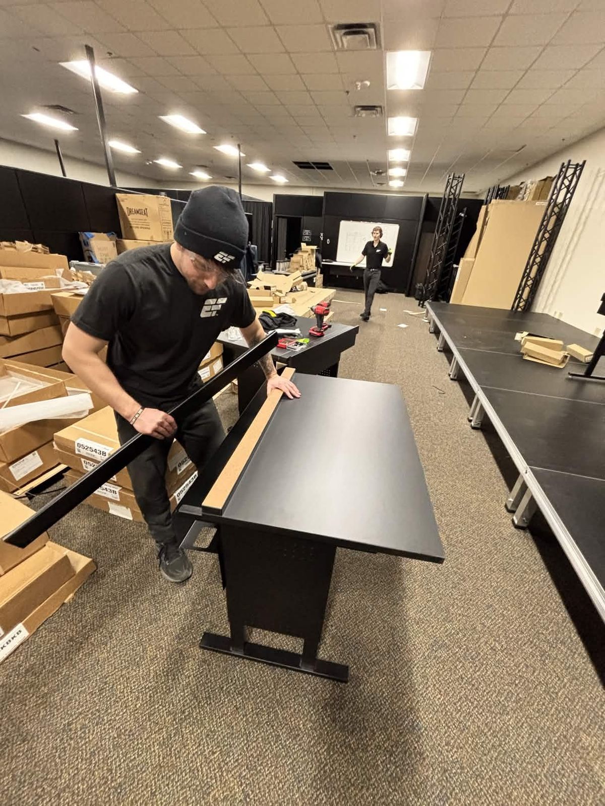 Crew assembling competition desks during an arena buildout