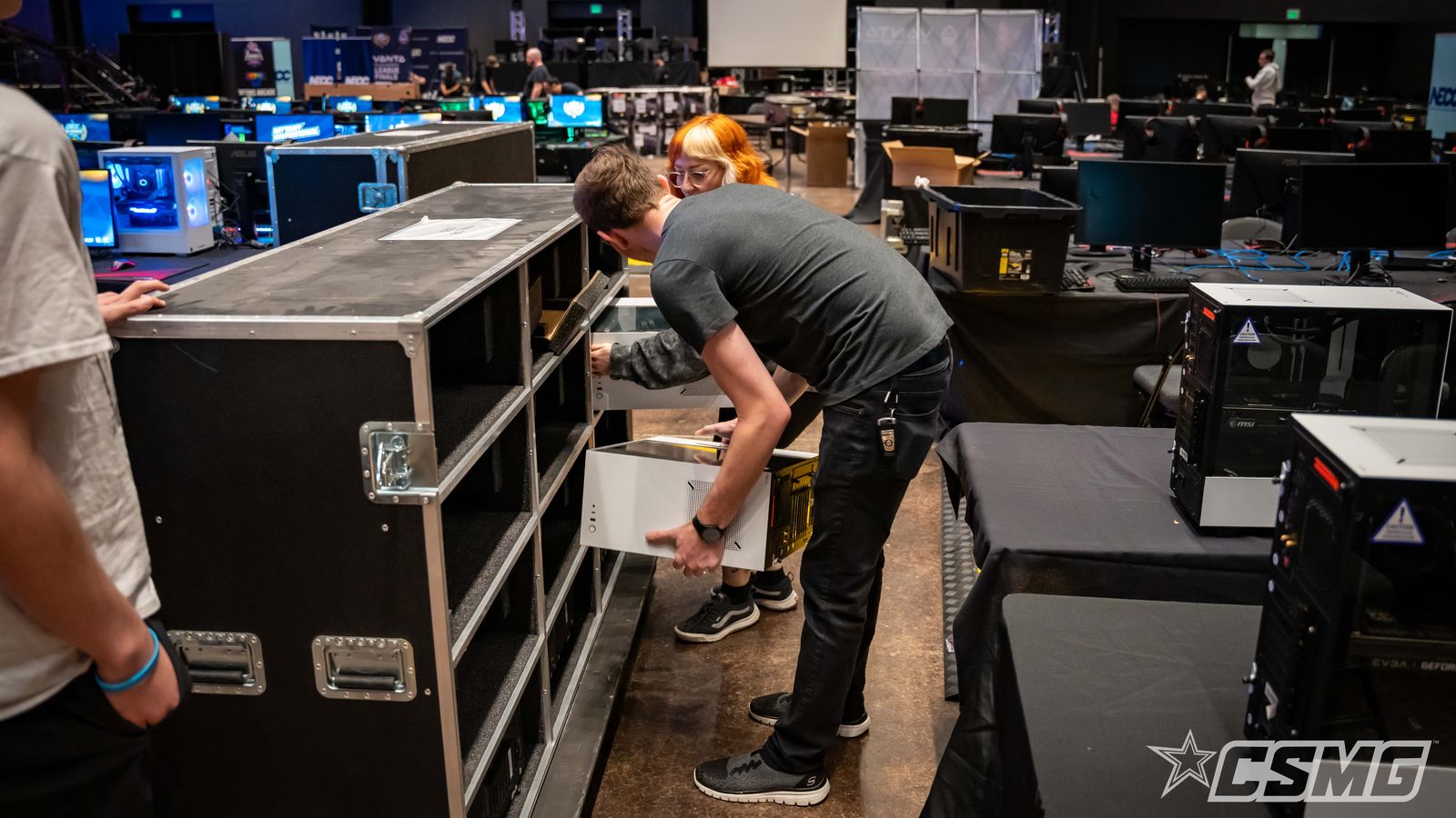 Crew member unpacking a PC road case on a tournament floor